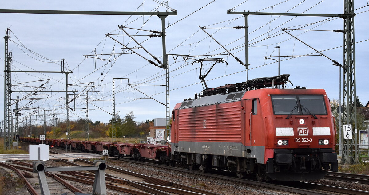 DB Cargo AG, Mainz [D] mit ihrer  189 062-3  [NVR-Nummer: 91 80 6189 062-3 D-DB] und einem Ganzzug Containertragwagen (leer) am 04.11.25 Höhe Bahnübergang Bahnhof Rodleben.