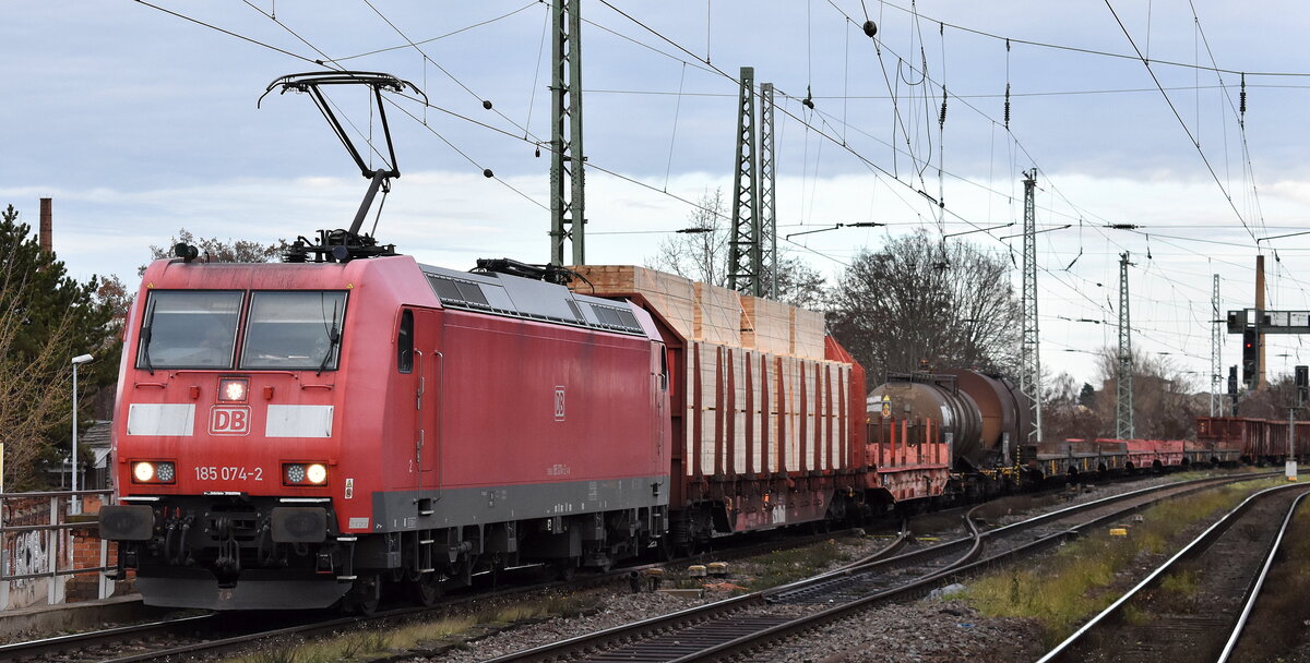 DB Cargo AG, Mainz [D] mit ihrer  185 074-2  [NVR-Nummer: 91 80 6185 074-2 D-DB] und einem gemischten Güterzug am 08.12.25 Höhe Bahnhof Magdeburg-Neustadt.