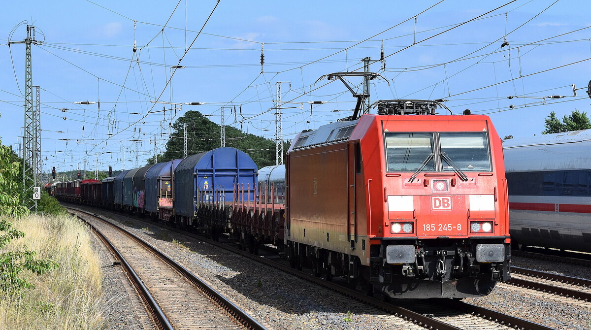 DB Cargo AG, Mainz mit ihrer  185 245-8  [NVR-Nummer: 91 80 6185 245-8 D-DB] und einem gemischten Güterzug Höhe Bahnhof Saarmund am 25.06.25