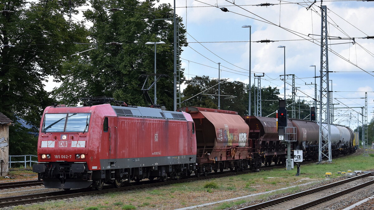 DB Cargo AG, Mainz mit ihrer  185 062-7  [NVR-Nummer: 91 80 6185 062-7 D-DB] und einem gemischten Güterzug am 30.07.25 Höhe Bahnhof Ruhland. 