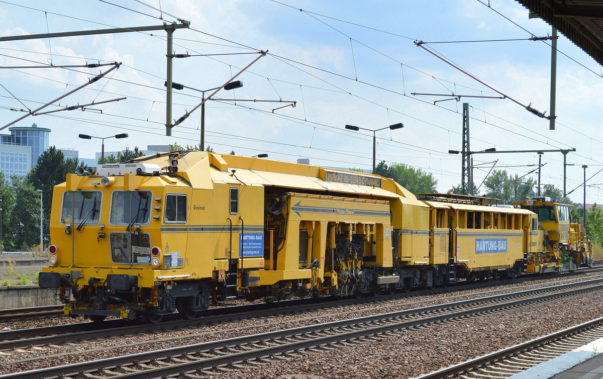 Die Fa. HARTUNG-BAU mit ihrer Gleisstopfmaschine von P&T Typ UNIMAT 09-32/4S DYNAMIC und am Haken einen Schotterplaniermaschine vom Typ SSP 110 SW am 29.07.16 Durchfahrt Bf. Flughafen Berlin-Schönefeld.