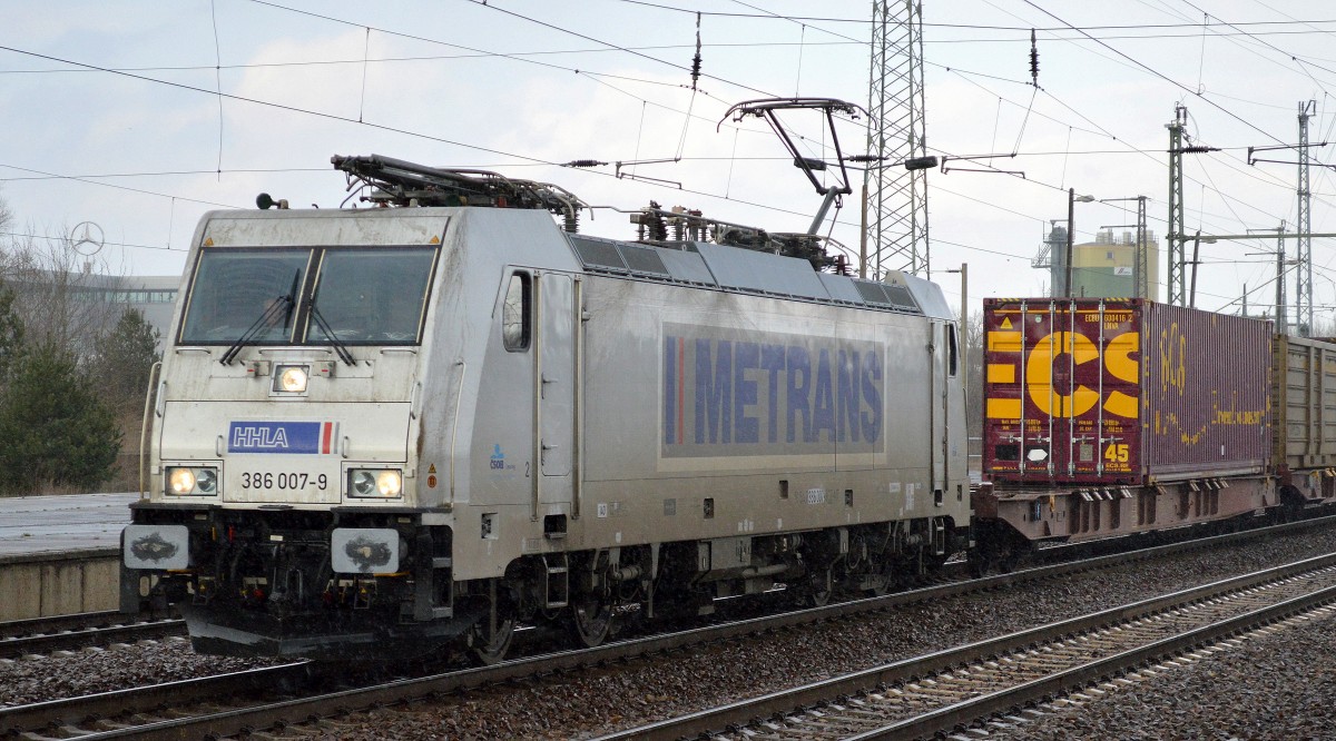 Die METRANS 386 007-9 war am 27.03.15 mit Containerzug unterwegs, es regnete in Strömen im Bhf. Flughafen Berlin-Schönefeld als der Zug durchfuhr.