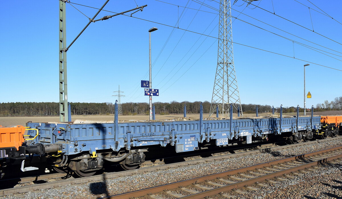 Drehgestell-Flachwagen mit klappbaren Seiten- und Stirnklappen u. Rungen vom Einsteller ERR European Rail Rent GmbH mit der Nr. 37 TEN 80 D-ERR 3988 076-0 Rens beladen mit Beton Gleisbohlen in einem Ganzzug am 18.03.25 Höhe Bahnhof Rodleben.