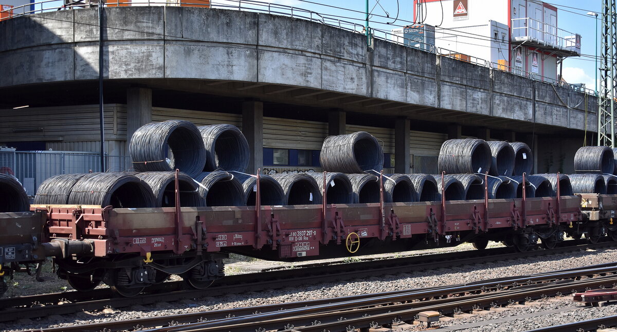 Drehgestell-Flachwagen mit vier Radsätzen, mit Seiten- und Stirnwandklappen und mit Rungen der DB Cargo beladen mit Stahldrahtrollen. Mit einer Ladelänge von 18,50 m dienen diese Wagen zur Beförderung von schweren, langen Erzeugnissen der Eisen- und Stahlindustrie und Fertigbauteilen, Holz, Kleineisenzeug, Halbzeug, Steinen, Fahrzeugen u.a.m. Der Wagen im Bild trägt die Nr. 31 RIV 80 D-DB 3937 297-0 Res 687 in einem Ganzzug am 20.05.25 Höhe Bahnhof Hamburg-Harburg.