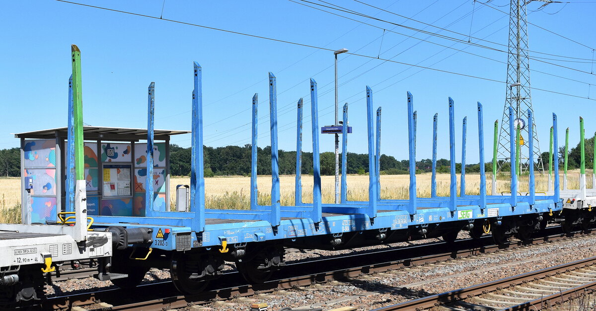 Drehgestell-Flachwagen mit vier Radsätzen und Niederbindeeinrichtung für die Beförderung von Stamm- und Schnittholz vom Einsteller S-Rail GmbH (SETG) mit der Nr. 83 TEN 80 D-SRA 4723 202-3 Snps in einem Ganzzug  am 01.07.25 Höhe Bahnhof Rodleben.
