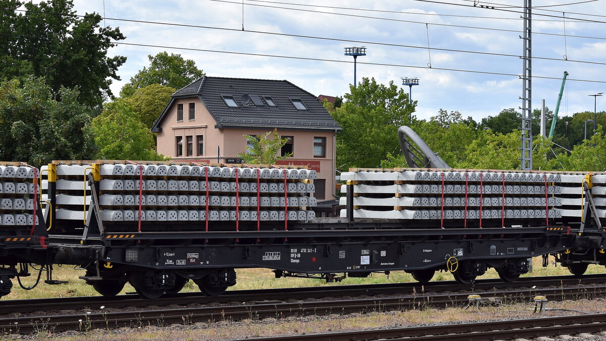 Drehgestell-Oberbaustoffwagen der DB Cargo mit der Nr. 88 RIV 80 D-DB 4733 341-2 Slmmps mit Beton-Bahnschwellen beladen in einem Ganzzug am 10.07.25 Höhe Bahnhof Magdeburg Hbf.