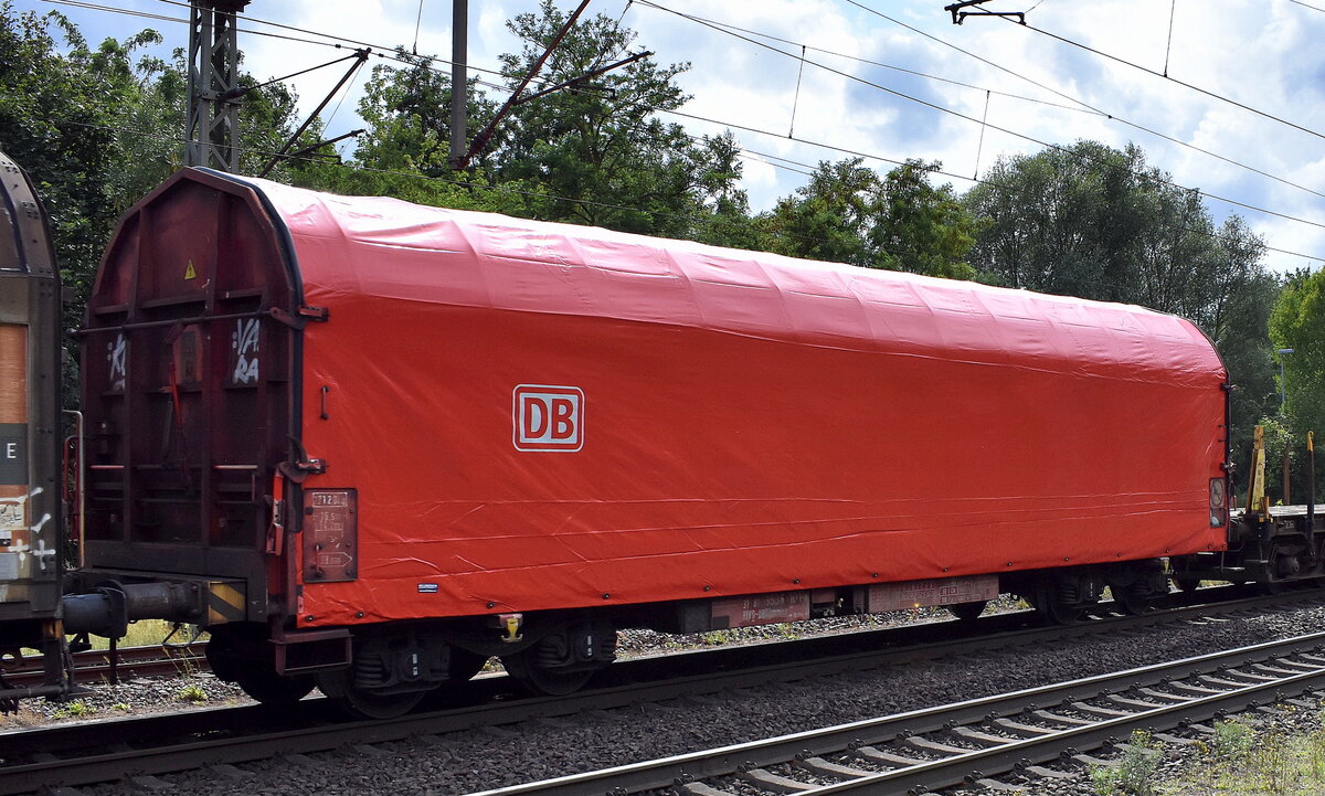 Drehgestellflachwagen mit vier Radsätzen, mit verschiebbarem Planenverdeck und mit Rungen der DB Cargo mit der Nr. 31 RIV 80 D-DB 3536 101-9 Rijmmns 660. Diese Drehgestell-Flachwagen eignen sich aufgrund des Planenverdecks besonders zum Transport nässeempfindlicher Güter. Hier der Wagen in einem gemischten Güterzug am 01.08.25 Höhe Bahnhof Niederndodeleben.