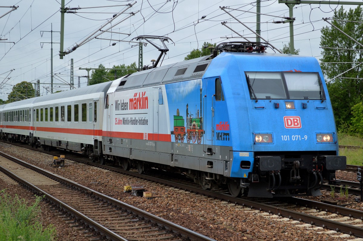 Eigentlich war ich happy unerwartet auch mal die relativ neue Märklin Werbe 101ér (101 071-9) mit IC-Wagengarnitur zu erblicken! Aber wie so oft schon in den Vorjahren stelle ich mir die Frage, warum gelingt es der DB trotz vielfacher Kritik in den Vorjahren nicht ihre Folien auf den Loks qualitativ hochwertig zu befestigen, das sie wenigstens ein paar kurze Monate ohne Beschädigungen durch die Lande fahren, was macht man in Österreich und Schweiz anders und besser?, denn das Wetter in den Alpen dürfte ja wohl etwas ruppiger sein als in deutschen Gefilden im allgemeinen oder sind unsere Waschstraßen für die deutschen Loks zu massiv für die befestigten Folien der DB, jedenfalls blinkt am oberen Fensterrahmen der Lok schon wieder das übliche DB-Rot hervor, fällt bei blauer Farbe sofort ins Auge und würde mich als Werbekunde echt erzürnen, 01.06.15 Durchfahrt Bhf. Flughafen Berlin Schönefeld.
