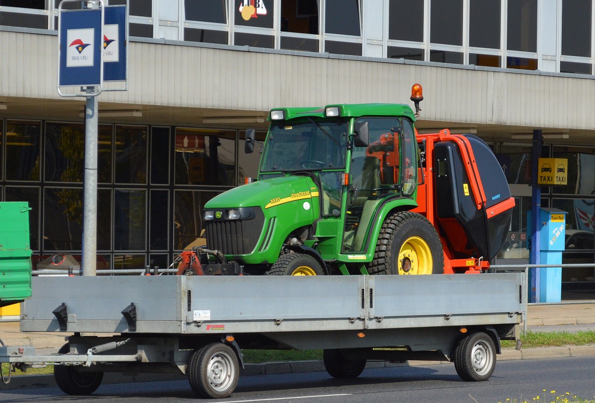 Ein JOHNE DEERE 3320 Kompkttraktor mit Allradantrieb hier auf einem Hänger mit Anbauten der Gemeinde Schönefeld bei Berlin am 16.09.14 Bhf. Flughafen Berlin-Schönefeld.