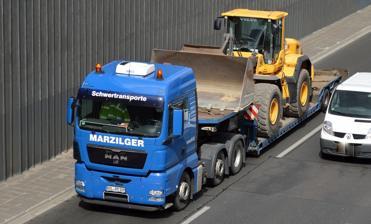 Ein MAN TGX 26.480 mit Tiefladebrücke (Schwertransport)der Fa. MARZILGER und einem VOLVO L110G Radlader (Mietbaumaschine) auf der Ladefläche am 13.04.15 Berliner Stadtautobahn Höhe Kaiserdamm.