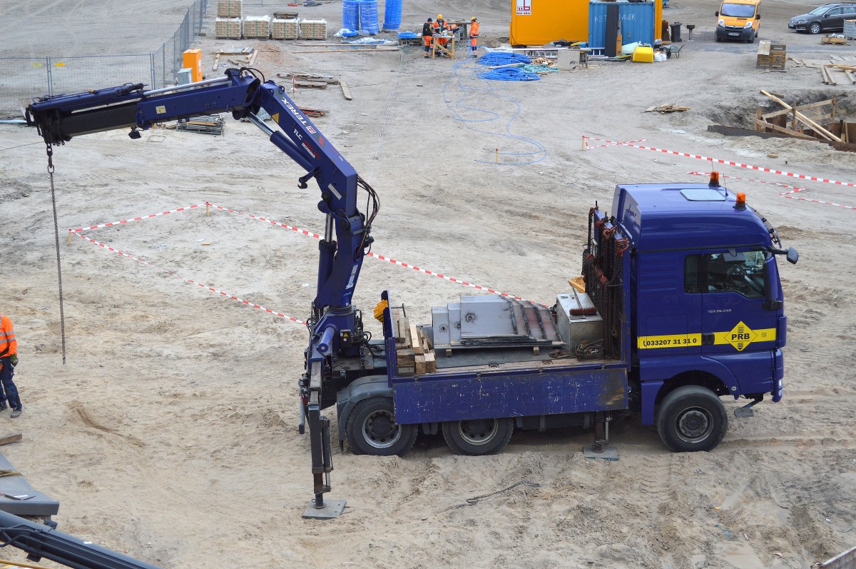 Ein MAN TGX 26.540 Pritschen-LKW (Selbstlader) der Fa. PRB l�dt schwere Stahlplatenn ab am 22.04.15 Gro�baustelle Berlin Wedding Neubau S21.