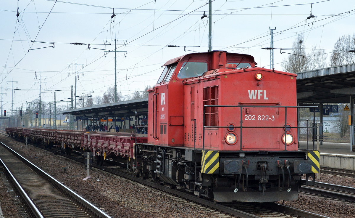 Einer von den vielen täglichen Bauzüge, die WFL Lok 15/202 822-3 mit einigen Drehgestell-Flachwagen bei der Durchfahrt Bf. Flughafen Berlin-Schönefeld, 29.03.17