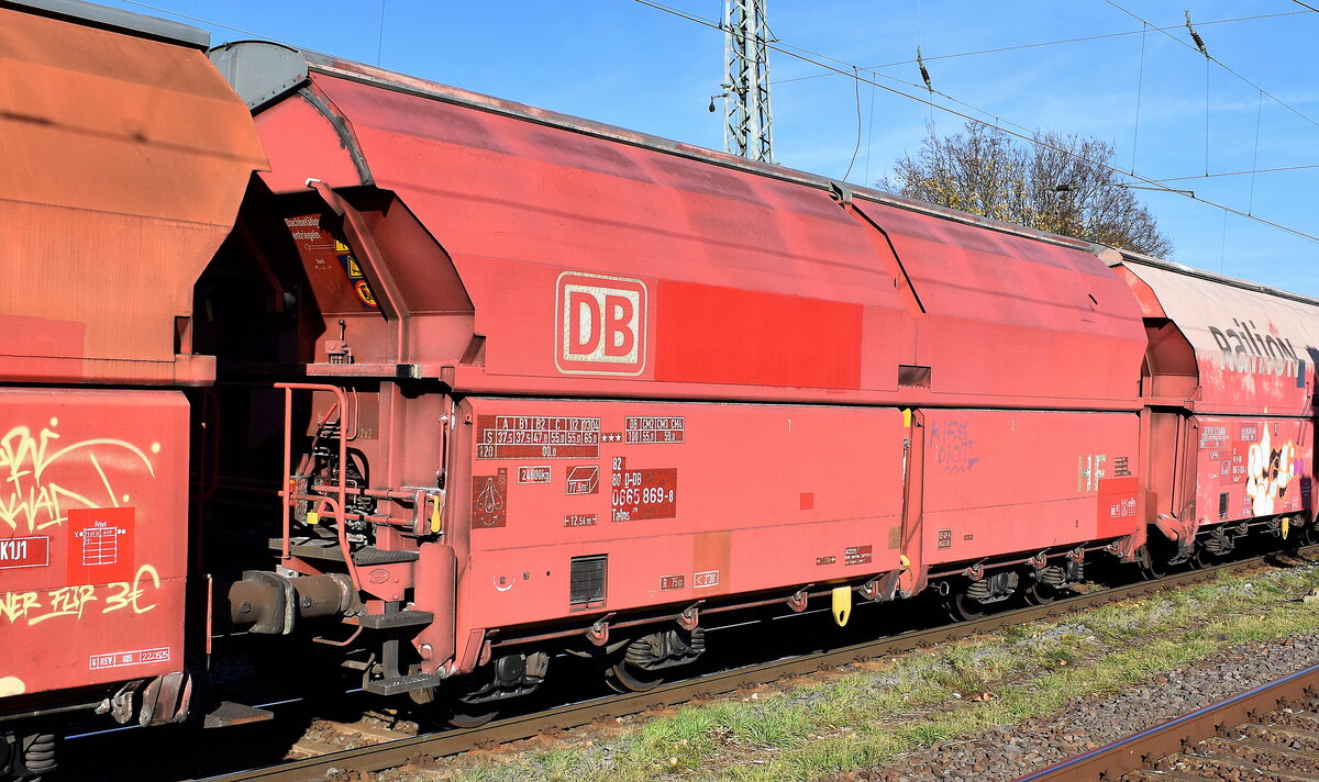 Gedeckter Schüttgutwagen mit schlagartiger Schwerkraftentladung, hydraulischem Klappenverschlusssystem und vier Radsätzen der DB Cargo mit der Nr. 82 80 D-DB 0665 869-2 Talns 970 in einem Ganzzug am 06.11.25 Höhe Bahnhof Magdeburg-Neustadt.