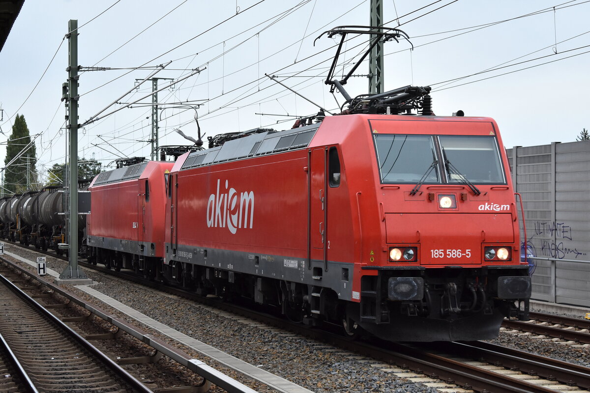 Hanse Bahn Nord GmbH, Glinde [D] (ELBECARGO Gruppe) mit der geleasten Akiem Lok  185 586-5  [NVR-Nummer: 91 80 6185 586-5 D-AKIEM] u. der BRLL Lok  145 090-7  und Kesselwagenzug (geschmolzener Schwefel) am Haken am 22.09.25 Höhe Bahnhof Berlin Karow.