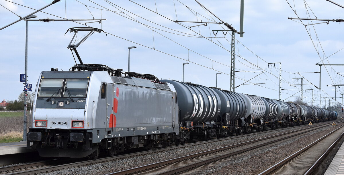 HSL Logistik GmbH, Hamburg [D] mit der geleasten Akiem Lok  186 382-8  [NVR-Nummer: 91 80 6186 382-8 D-AKIEM] und einem Kesselwagenzug am 09.04.25 Höhe Bahnhof Rodleben.