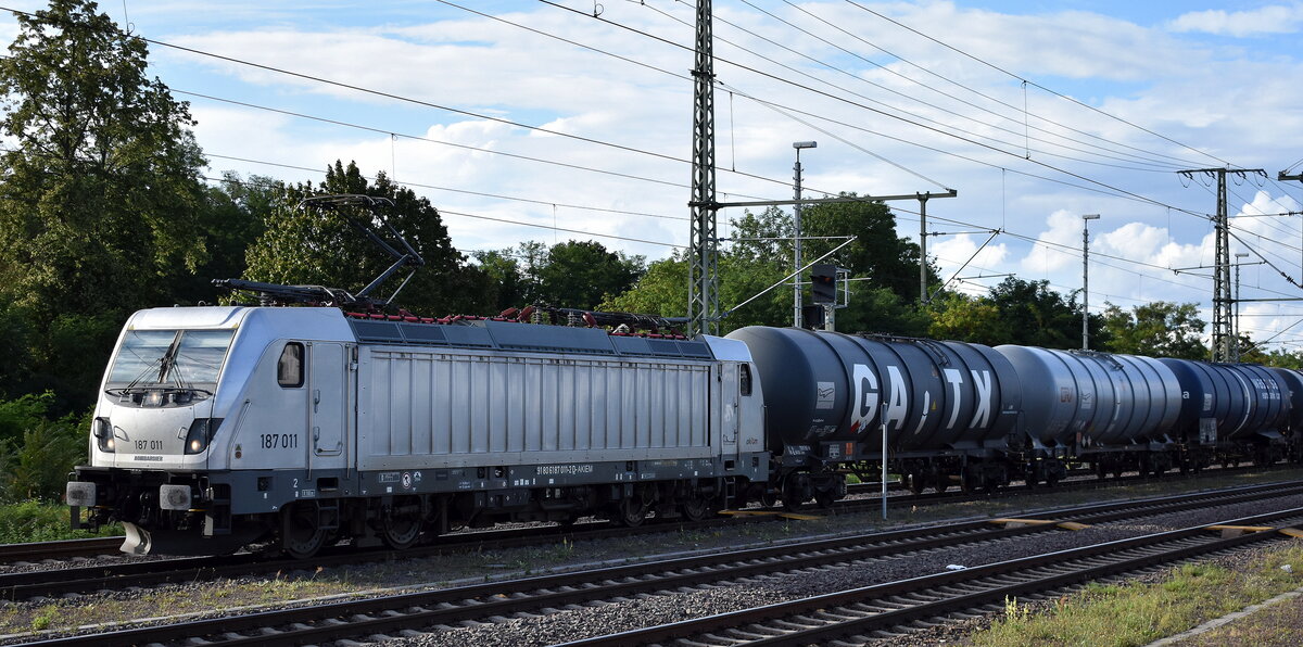 HSL Logistik GmbH, Hamburg [D] mit der geleasten Akiem Lok  187 011  [NVR-Nummer: 91 80 6187 011-2 D-AKIEM] und einem Kesselwagenzug (für Kerosin) am 01.08.25 Höhe Bahnhof Magdeburg. Hbf.