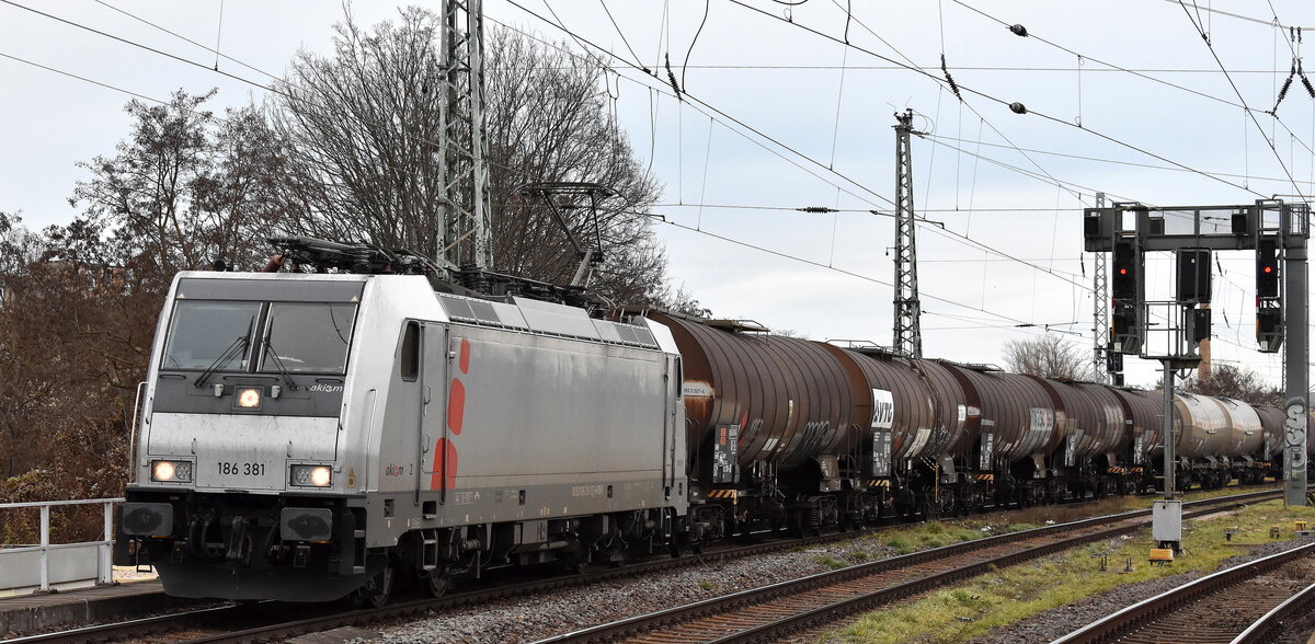 HSL Logistik GmbH, Hamburg [D] mit der geleasten Akim Lok  186 381  [NVR-Nummer: 91 80 6186 381-0 D-AKIEM] und einem Kesselwagenzug (für Befüllung mit Eisessig oder Essigsäure, Lösung mit mehr als 80 Masse-% Säure) am 08.12.25 Höhe Bahnhof Magdeburg-Neustadt.
