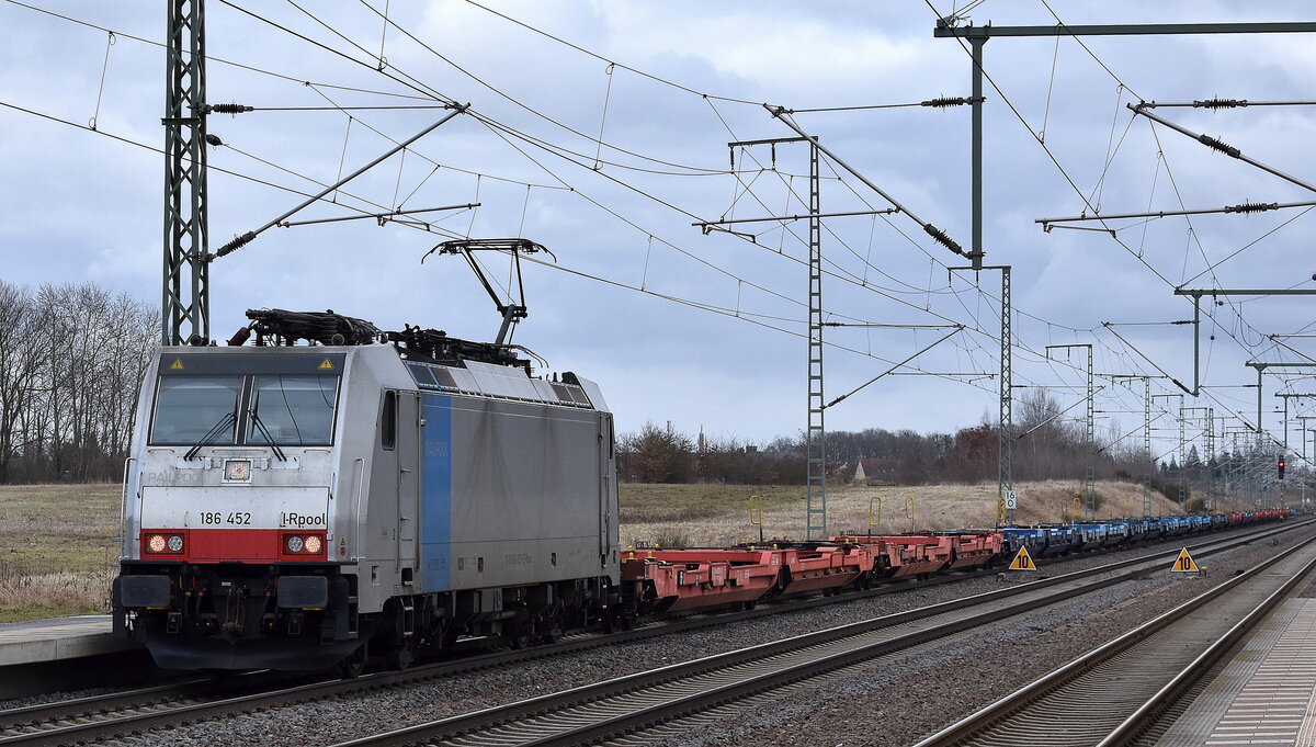 HSL Logistik GmbH, Hamburg [D] mit der geleasten Railpool Lok  186 452-9  [NVR-Nummer: 91 80 6186 452-9 D-Rpool] und einem Ganzzug Taschenwagen (leer) am 24.02.26 Höhe Bahnhof Rodleben.