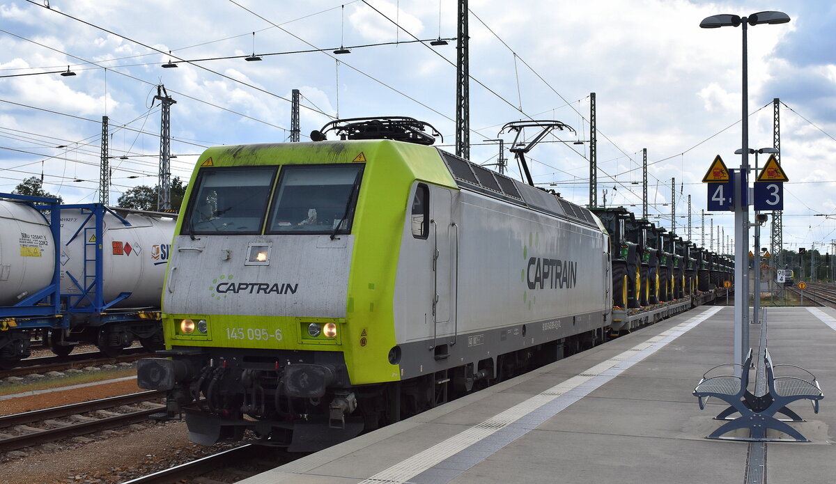 ITL - Eisenbahngesellschaft mbH, Dresden [D] mit ihrer  145 095-6  [NVR-Nummer: 91 80 6145 095-6 D-ITL] und einem halbierten Güterzug, vorne mit Transportwagen mit fabrikneuen JOHN DEEERE Traktoren dahinter Containerzug am 30.07.25 Durchfahrt Bahnhof Ruhland.