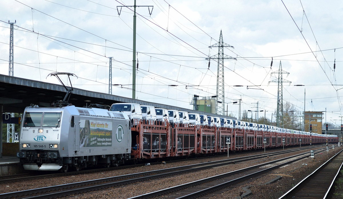 ITL mit 185 548-5 und langem PKW-Transportzug mit fabrikneuen VW Nutzfahrzeugen am 26.04.16 Durchfahrt Bhf. Flughafen Berlin-Schönefeld.