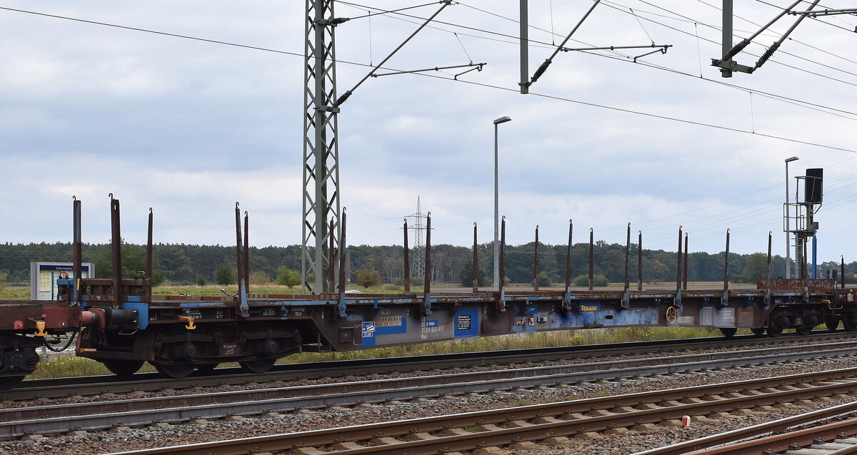 Langer Drehgestell-Flachwagen mit Rungen vom Einsteller Touax Rail Group mit deutscher Registrierung mit der Nr. 83 80 D-TOUAX 350 9 045-0(P) Rbs in einem gemischten Güterzug  am 01.10.25 Höhe Bahnhof Rodleben.