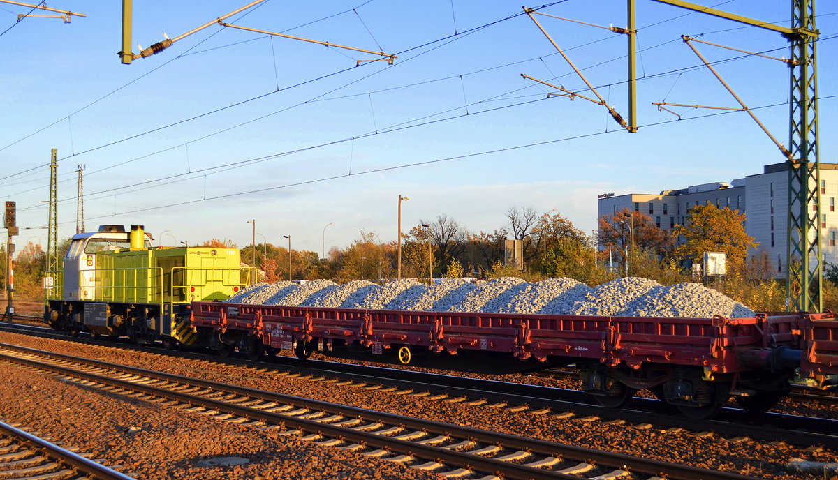 Locon mit der Alpha Trains 1138 (275 119-6) und einem recht langen Schotterzug bei untergehender Sonne im Bf. Flughafen Berlin-Schönefeld.