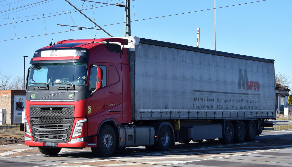 M Sped Internationale Frachtlogistik aus Lettland mit einem Sattelzug mit VOLVO FH 460 EURO6 Zugmaschine am 18.03.25 Höhe Bahnübergang Bahnhof Rodleben.