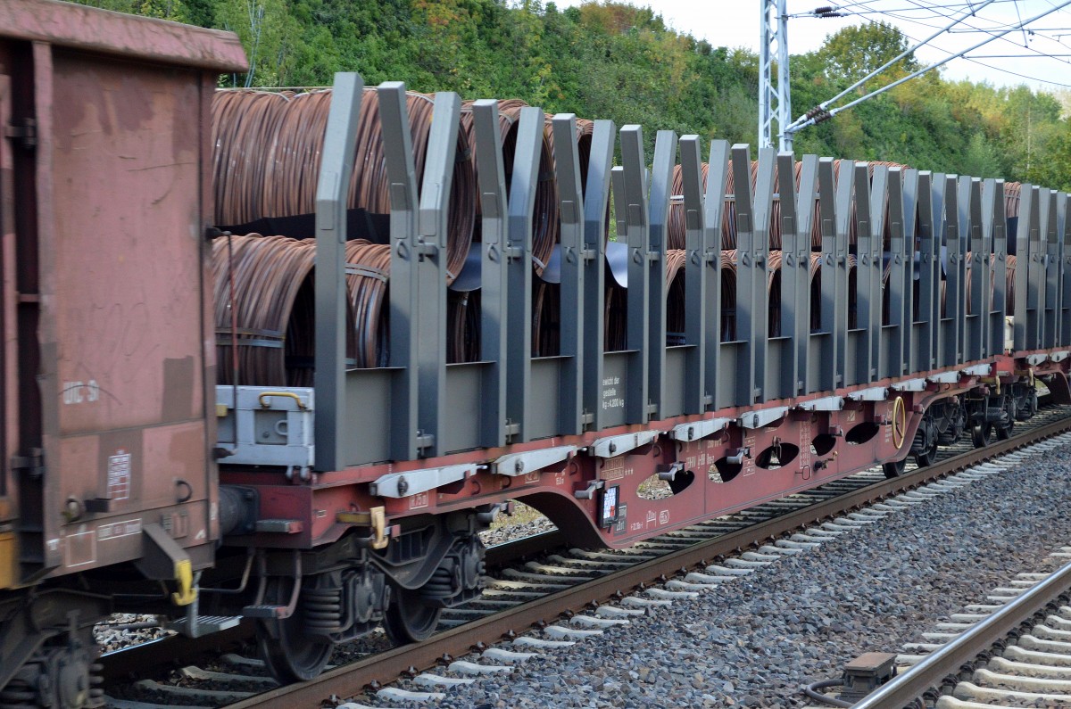 Österreichischer Drehgestell-Flachwagen mit Rungen und Spezialaufsatz für Drahtrollen vom Typ Rns-z der ÖBB mit einigen gleichartigen Güterwagen in einem gemischtem Güterzug am 23.09.14 Berlin-Hohenschönhausen.