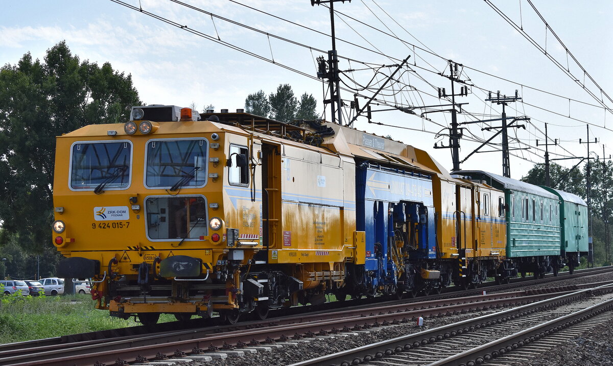 Polnische P&T Unimat 09-475/4S Y Universal-Stopfmaschine der Fa. Zakład Robót Komunikacyjnych – DOM w Poznaniu Sp. z o.o. mit der Nr. 99 51 PL-ZRKPN 9425 015-7 und zwei Beiwagen am Haken am 13.08.25 Höhe Bahnhof Kostrzyn nad Odrą.