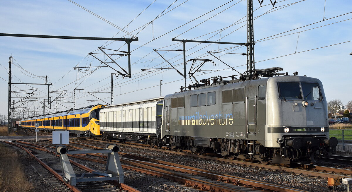 RailAdventure GmbH mit ihrer  111 082-4  (NVR:  91 80 6111 082-4 D-RADVE ) mit der Überführung von einem  Coradia Stream Elektotriebzug der NS - Nederlandse Spoorwegen N.V.  3207  am 18.12.25 Höhe Bahnhof Rodleben.