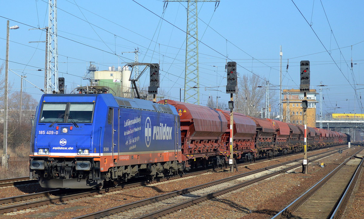 Raildox mit der 185 409-0 und einem Ganzzug gedeckter Schüttgutwagen (Düngemittel) am 14.02.17 Durchfahrt Bf. Flughafen Berlin-Schönefeld.