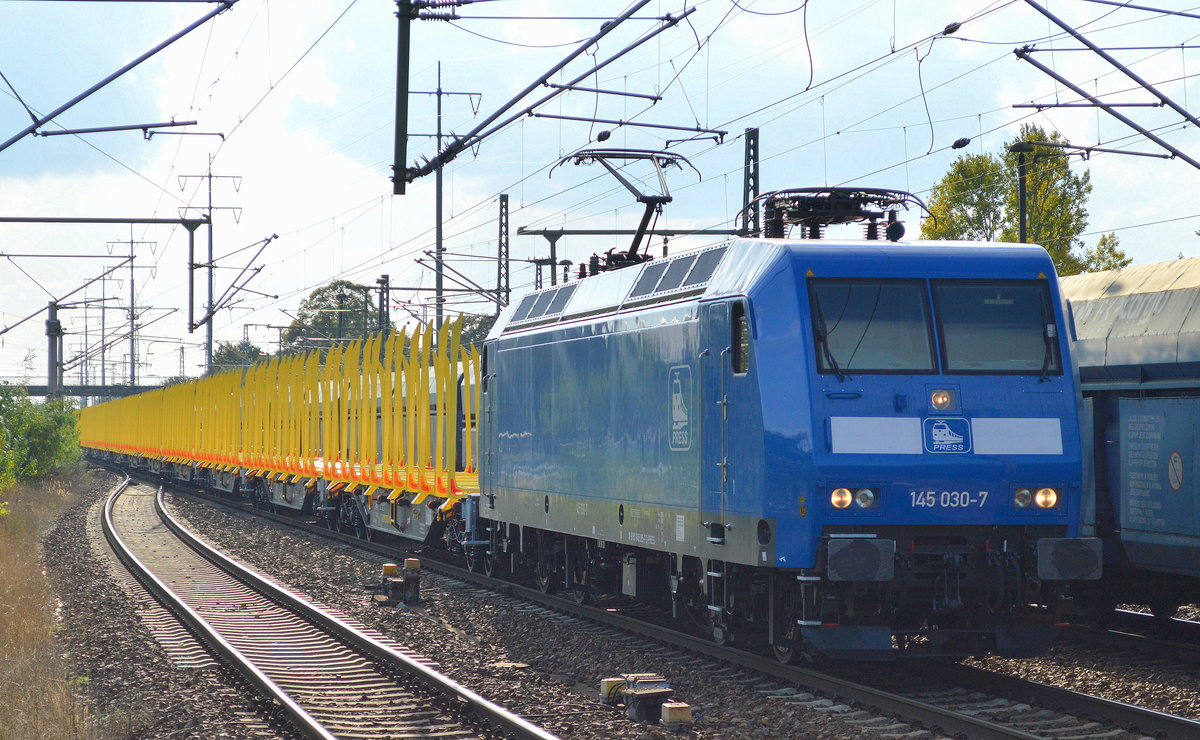 RESS 145 030-7 (145 085-7) mit genau diesen fabrikneuen Drehgestell-Flachwagen die auf der InnoTrans aktuell präsentiert wurde angemietet von TRANSWAGGON vom Typ Snps entgegen, dadurch das diese noch so gut wie gar nicht im Einsatz waren leuchten die gelben Rungen noch richtig intensiv, 21.09.16 Bf. Flughafen Berlin-Schönefeld.