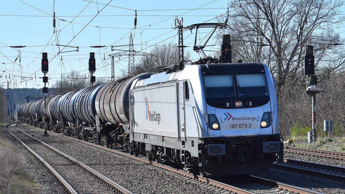RheinCargo GmbH & Co. KG, Neuss [D] mit ihrer  187 073-2  [NVR-Nummer: 91 80 6187 073-2 D-RHC] und einem Kesselwagenzug am 03.04.25 Höhe Bahnhof Saarmund.
