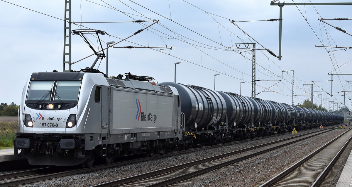RheinCargo GmbH & Co. KG, Neuss [D] mit ihrer  187 070-8  [NVR-Nummer: 91 80 6187 070-8 D-RHC] und einem Kesselwagenzug am 01.10.25 Höhe Bahnhof Rodleben.