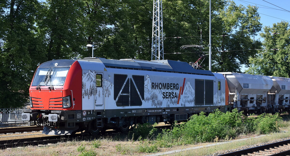 Rhomberg Sersa Gleisbau GmbH, Berlin [D] mit der von der BBW - Bahnbau Wels GmbH, Wels [A] angemieteten Vectron Dual Lok „248 997“  [NVR-Nummer: 90 80 2248 997-9 D-BBW] und einem Schotterzug (leer) am 30.06.25 Höhe Bahnhof Ruhland.