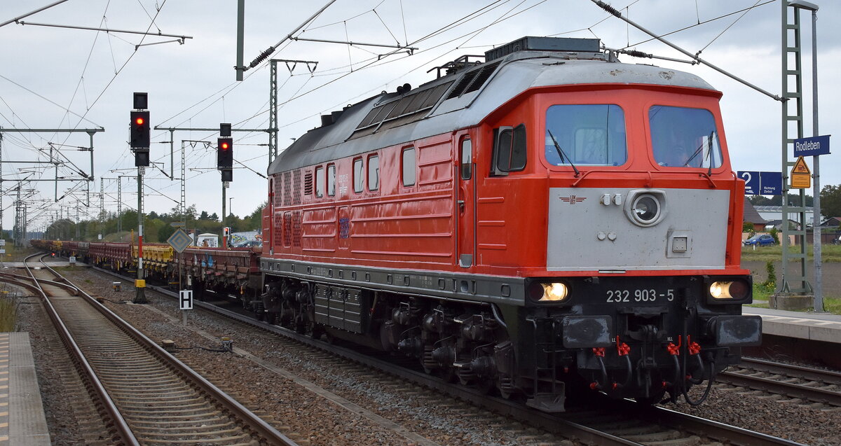 Salzland Rail Service GmbH, Bernburg (Saale) mit der angemieteten  232 903-5  [NVR-Nummer: 92 80 1232 903-5 D-OST] nd leeren Drehgestell-Flachwagen am 01.10.25 Höhe Bahnhof Rodleben.