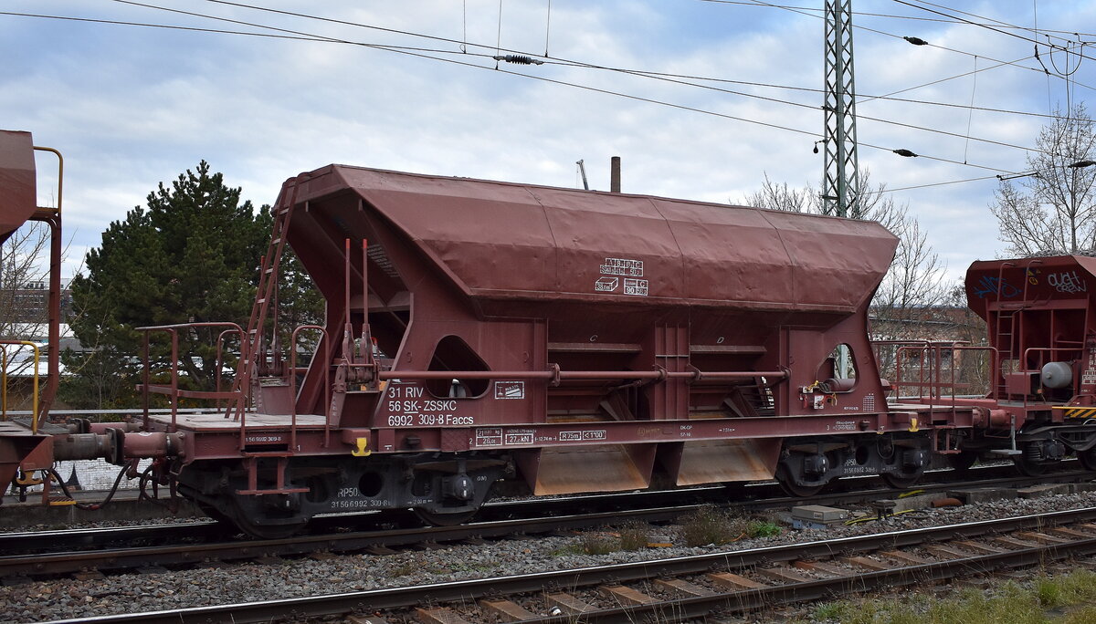 Slowakischer offener Selbstentladewagen in Sonderbauart mit vier Achsen (a) und einer dosierbaren Selbstentladung durch Schwerkraft für den Schottertransport der ZSSK Cargo mit der Nr. 31 RIV 56 SK-ZSSKC 6992 309-8 Faccs in einem Schotterzug am 03.12.25 Höhe Bahnhof Magdeburg Neustadt.