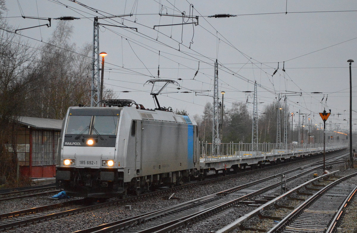 Super dunkel, beginnender Orkan mit Regen, da kam noch die Railpool-Lok 185 692-1 von HSL mit einem Ganzzug ganz neuer belgischer Drehgestell-Flachwagen zum Fahrzeug-Transport vom Typ Laadgrs der Fa. BLG Autorail am 22.02.17 Berlin-Hirschgarten. Grüße an den Tf. !!!