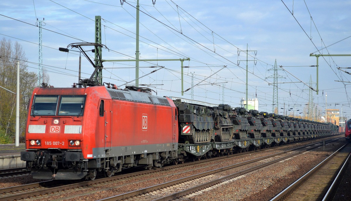 Und schon wieder ein Militärtransportzug, 185 007-2 mit einem Transportzug einer Bundeswehr-Panzergrenadiereinheit mit Bergepanzern, einer langen Reihe Schützenpanzer Typ  Marder  und mehreren Begleitfahrzeugen am 05.11.15 Bhf. Flughafen Berlin-Schönefeld.