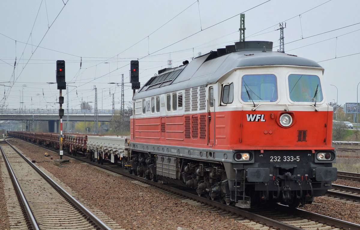WFL 232 333-5 mit Ganzzug Drehgestell-Flachwagen (leer) am 12.04.16 Durchfahrt Bhf. Flughafen Berlin-Schönefeld.