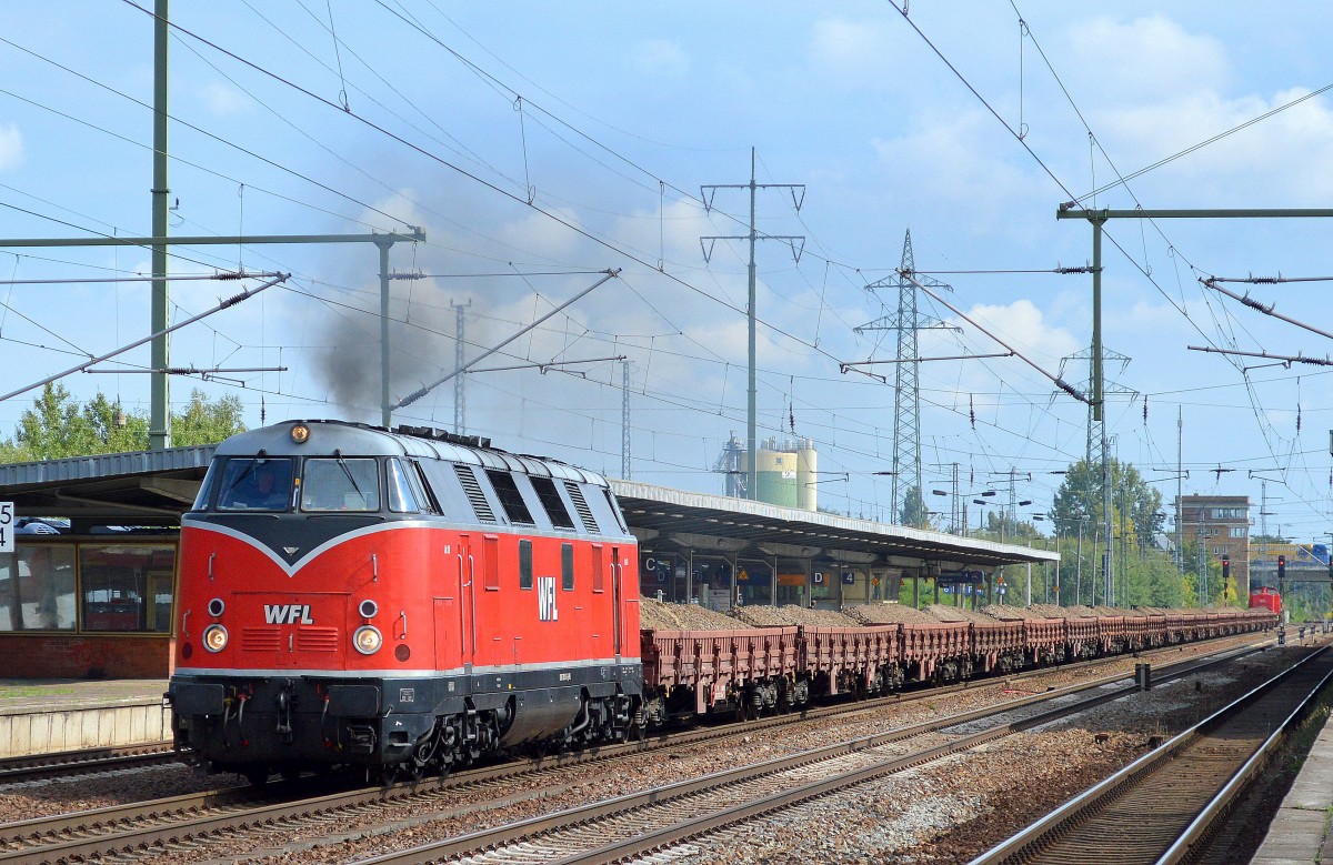 WFL LOK 20 (228 501-3) dampft mit Ganzzug Drehgestell-Flachwagen mit altem Gleisschotter beladen und WFL LOK 15 (202 822-3) hinten dran bei der Durchfahrt Bhf. Flughafen Berlin-Schönefeld, 03.09.14