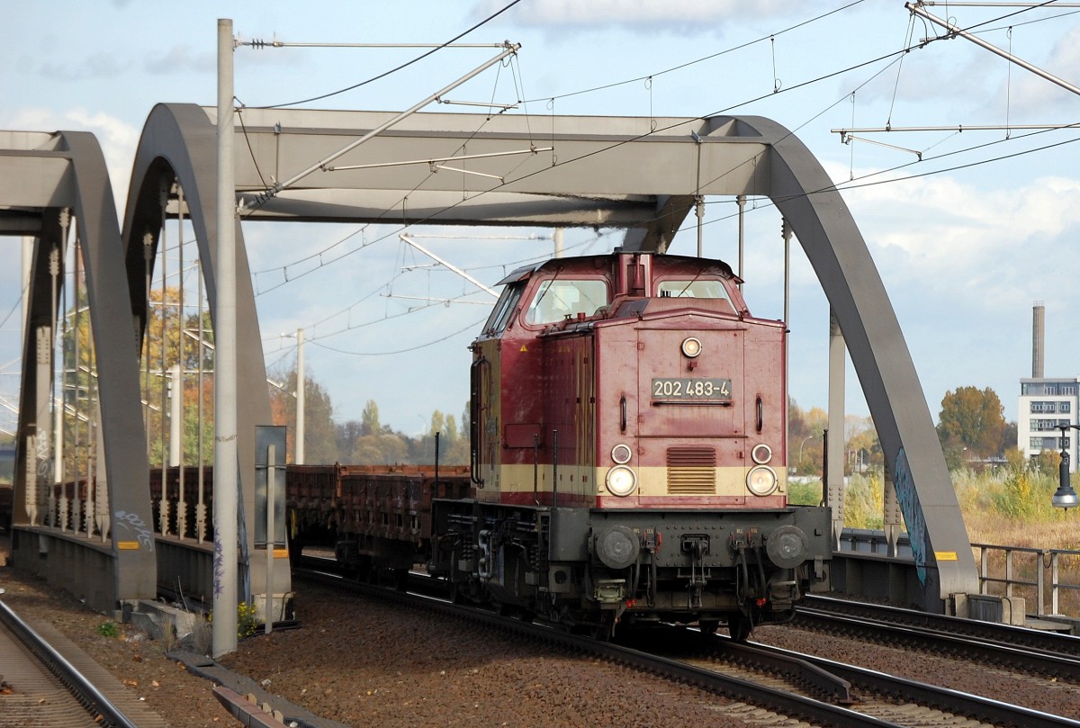 WFL Lok 24 202 483-4 (98 80 3202 483-4 D-WFL, LEW Bj.1972) mit einigen Drehgestell-Flachwagen mit Altschotter beladen Richtung Innenstadt, 21.10.13 Berlin-Pankow.