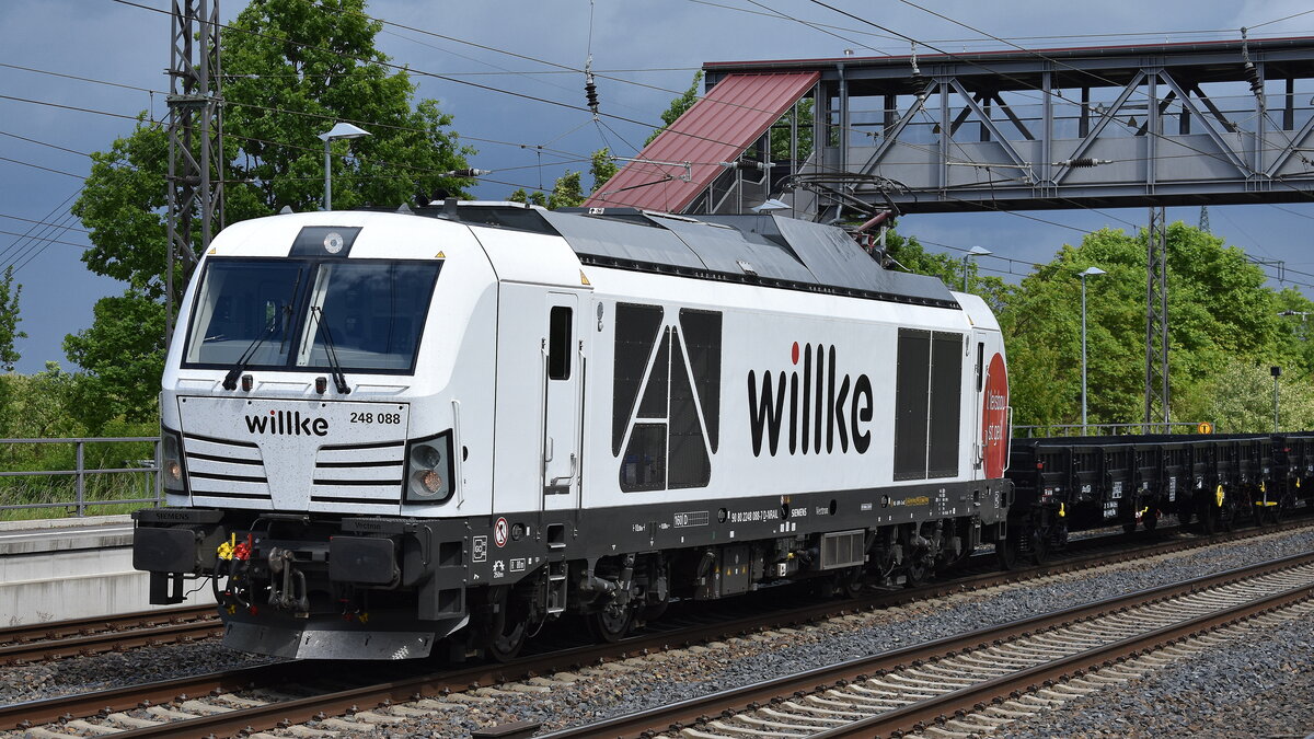 Willke Logistics GmbH mit der geleasten northrail Vectron Dual Lok  248 088 
[NVR-Nummer: 90 80 2248 088-7 D-NRAIL] und einem Ganzzug neuer firmeneigner schwarzer Drehgestell-Flachwagen am 16.05.25 Höhe Bahnhof Saarmund.