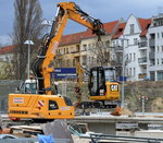 Ein LIEBHERR 918 compact Mobilbbagger der Fa.STRABAG hebt einen CAT 301.7D Minibagger (Mietbaumaschine) auf einen neu entstehenden Bahnsteig, 07.04.16 Großbaustelle Berlin Ostkreuz.