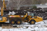 Erdarbeiten und Befüllen eines knickgelenkten Muldenkippers CAT 730C (Mietbaumschine) auf dem ehemaligen Bahngelände des Rangierbahnhofes Schöneweide in Berlin, Vorbereitung eines
