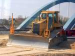 Bild durchs S-Bahnfenster, eine gro�e CAT D6N Raupe (Leasingbaumaschine) an der Bahnbaustrecke N�he Berlin-Adlershof, 24.04.10