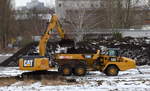 Raupenbagger CAT 324E (Mietbaumschine) bei Erdarbeiten und Befüllen eines knickgelenkten Muldenkippers CAT 730C auf dem ehemaligen Bahngelände des Rangierbahnhofes Schöneweide in