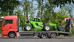 Ein MAN Transport-LKW mit einer HKL-Mietbaumaschine, einem MERLO P32.6L PLUS Teleskoplader auf der ladefläche am 15.05.17 Berlin-Marzahn.