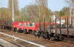 DB CARGO Drehgestellflachwagen mit vier Rads�tzen mit Stirnwandklappen auf diesem Bild ohne Rungen vom Typ Res  6?? in rot in einem amsonsten rein braunf�rbigen Zug, 11.04.11 Berlin-Karow.