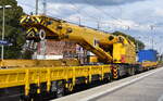 MGW Gleis- und Weichenbau GmbH, Berlin mit ihrem Gleisbauschienenkran MUTITASKER KRC 910 ( 99 80 9419 025-8 D-MGWB ) am Haken von ESL GmbH Lo  293 515-3  am 10.09.25 Durchfahrt Bahnhof Ruhland.